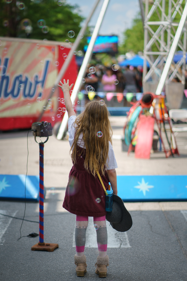 A little girl chasing bubbles at the Fort Wayne Buskerfest event.